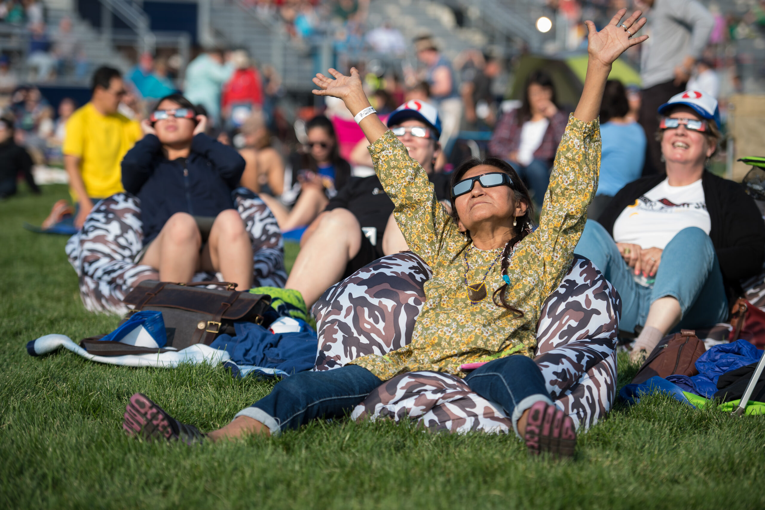 Eclipse observers sitting in grass