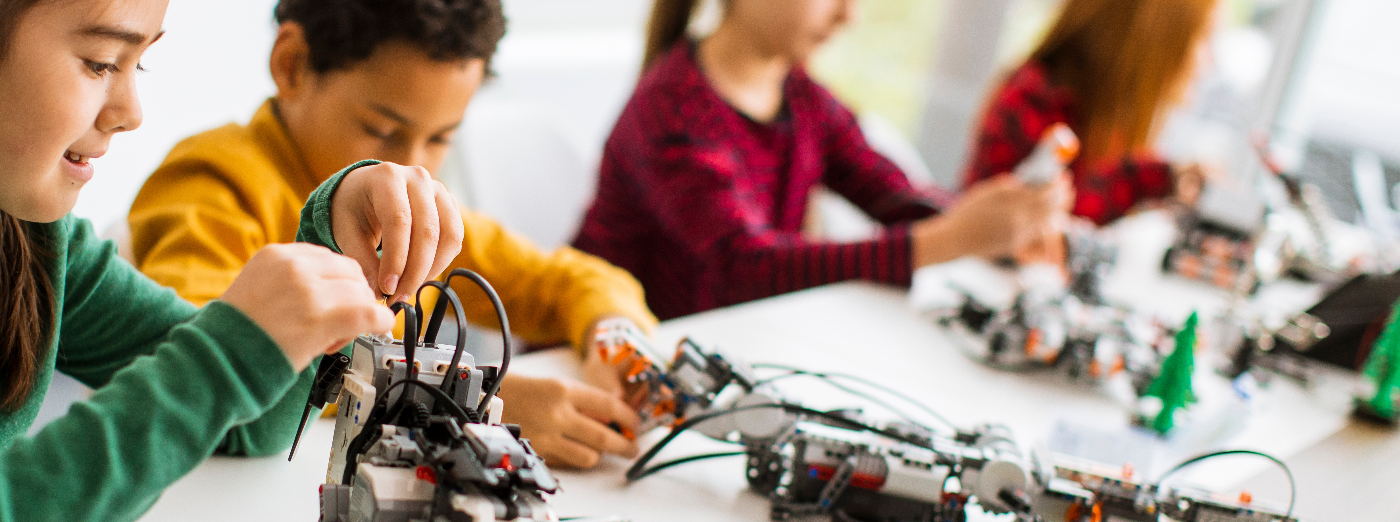 
		Girls and boys building robotics kits.		